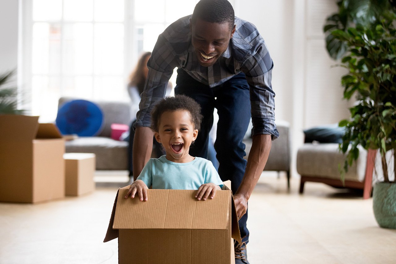 Black-father-and-son-playing-with-box-at-home